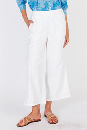 A model wearing the Pula Pant in colour White (White), from the front, cropped image