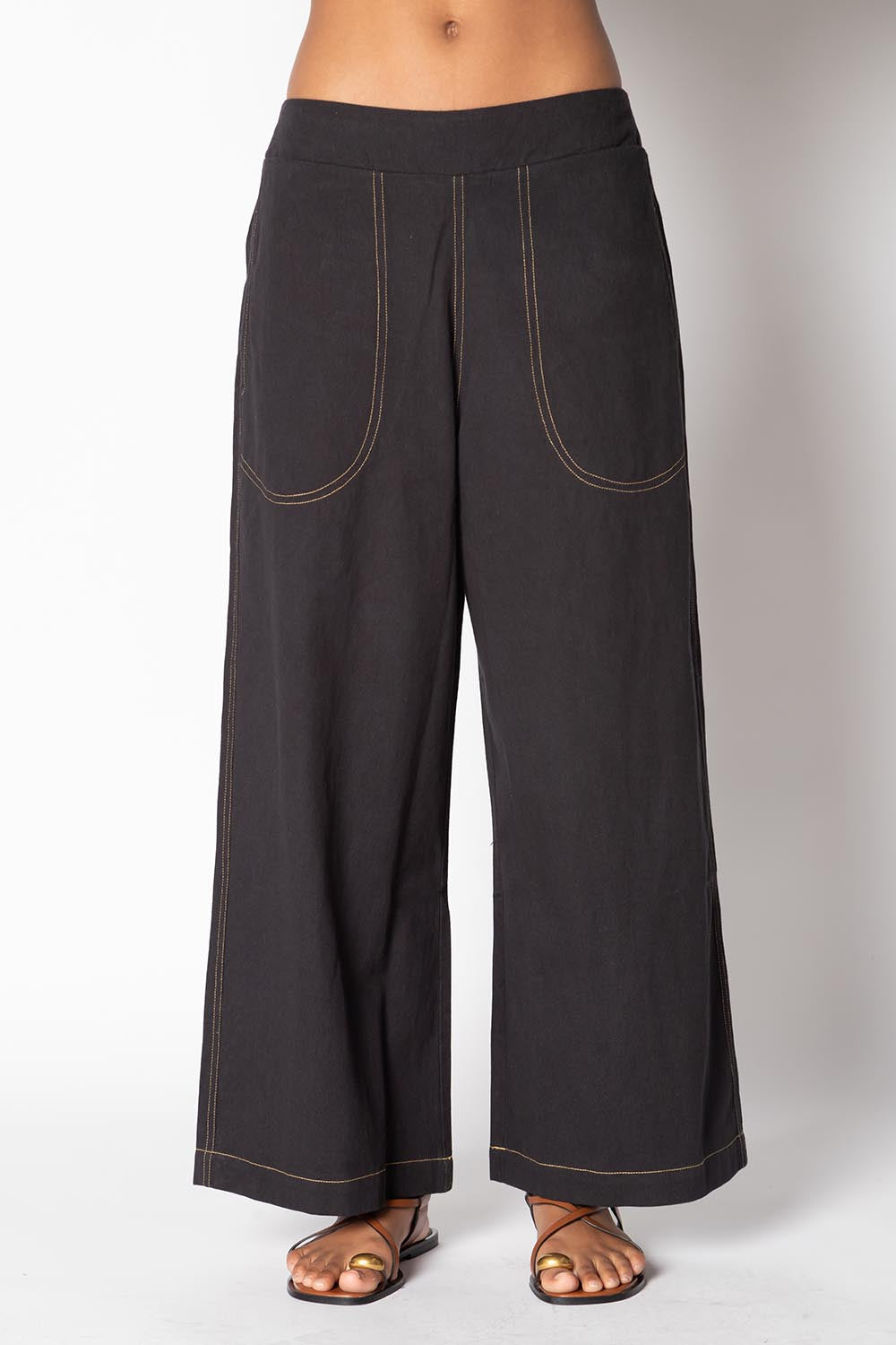 A model wearing the Pula Denim Pant in colour Black (Black), from the front, cropped image