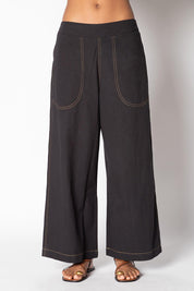 A model wearing the Pula Denim Pant in colour Black (Black), from the front, cropped image