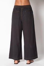 A model wearing the Pula Denim Pant in colour Black (Black), from the front, cropped image