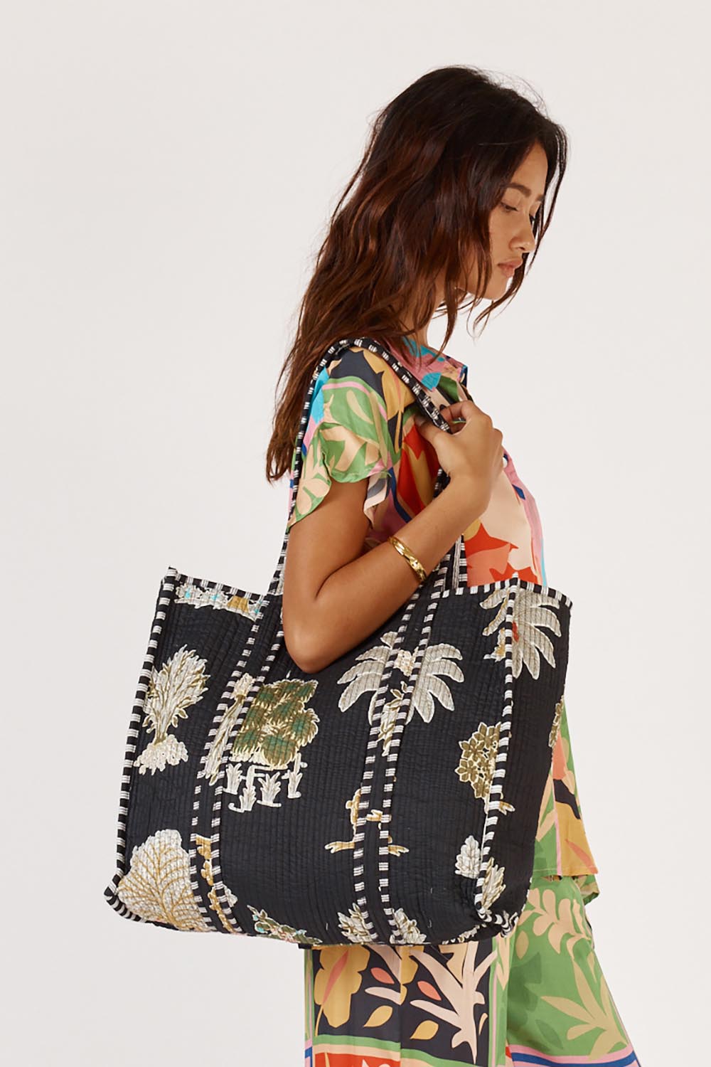A model wearing the Quilted Bag in colour Meadow (Blue), from the front, cropped image