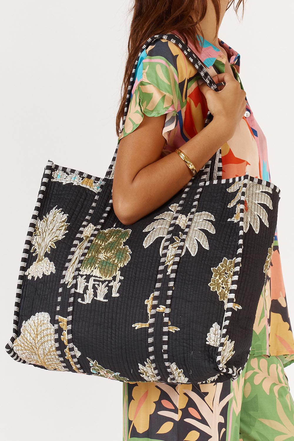 A model wearing the Quilted Bag in colour Meadow (Blue), from the front, cropped image