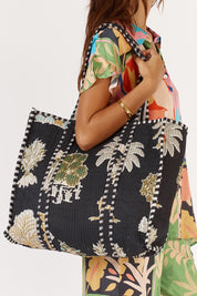 A model wearing the Quilted Bag in colour Meadow (Blue), from the front, cropped image