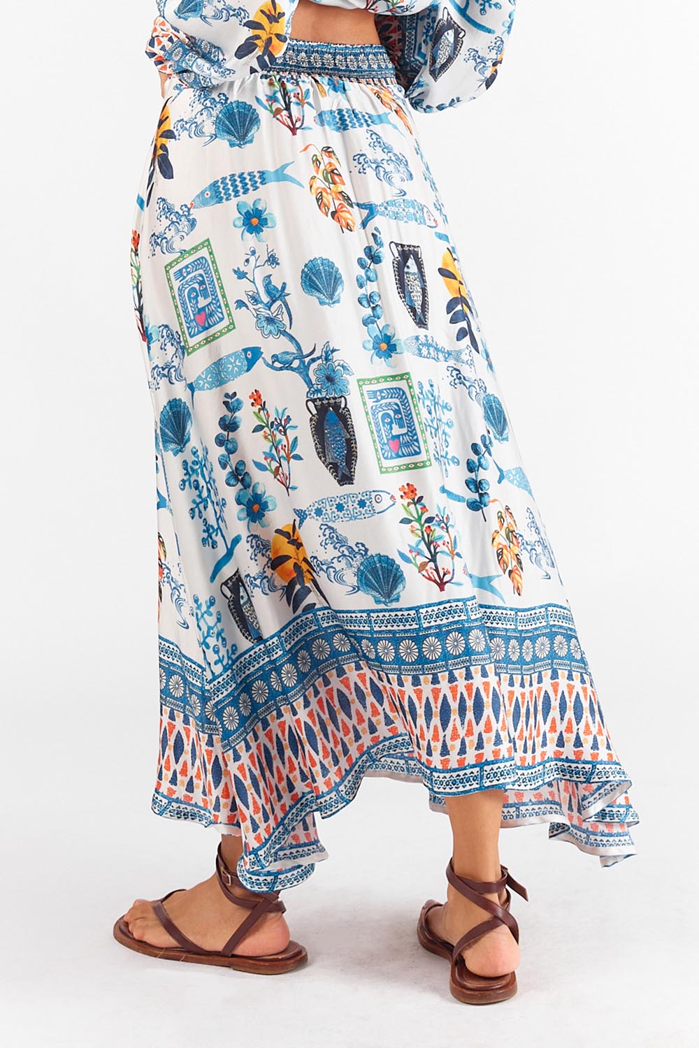 A model wearing the Sardinia Skirt in colour Multi (Blue), from the back