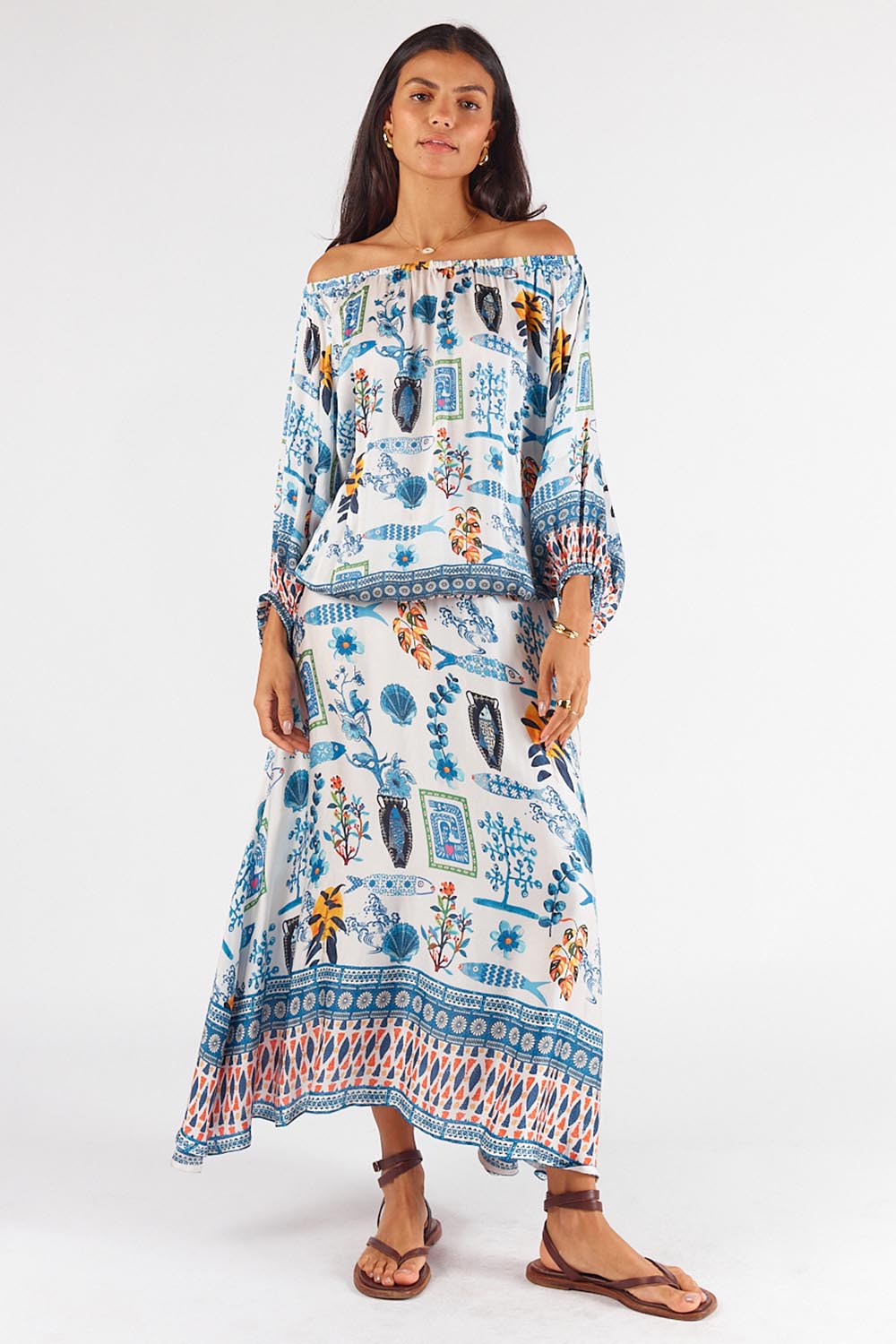 A model wearing the Sardinia Skirt in colour Multi (Blue), from the front, showing the whole outfit