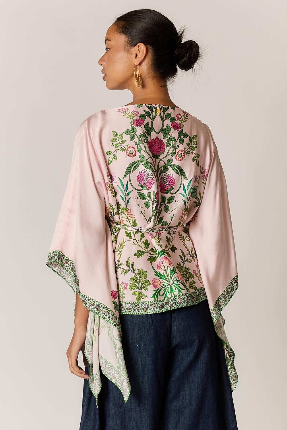 Model Genericm wearing size sample of the Tatiana Poncho – Pink in colour Pink, from the back