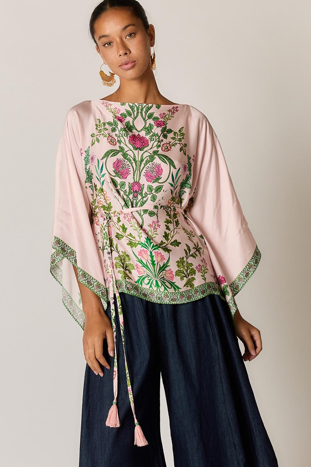 Model Genericm wearing size sample of the Tatiana Poncho – Pink in colour Pink, in a cropped view
