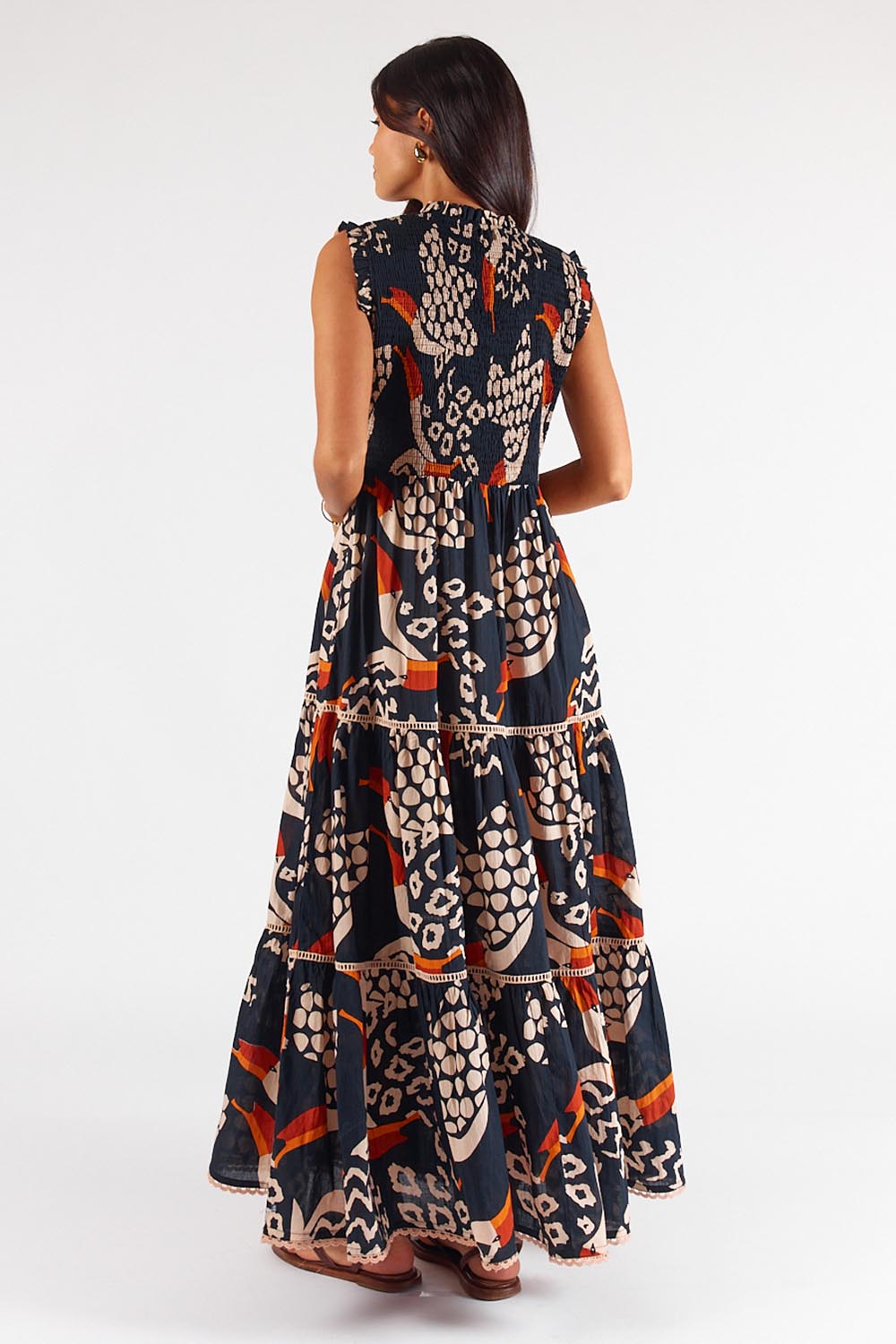 A model wearing the Toucan Cotton Maxi Dress in colour Multi (Black), from the back