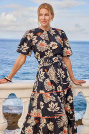Model Genericm wearing size sample of the Tucan Cotton Maxi Dress – Black in colour Black, in a cropped view