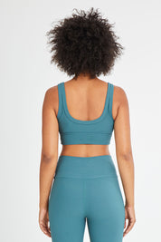 Model Olivia wearing size 10 of the Scoop It Up Sports Bra in colour Sage (Green), from the back
