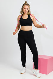 Model Jess wearing size 14 of the Power Up Cross Back Sports Bra in colour Black (Black), from the front, showing the whole outfit