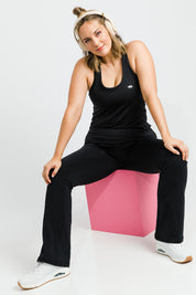 Model Jess wearing size 14 of the Back To Bare Action Bk Tank in colour Black (Black), from the front, showing the whole outfit