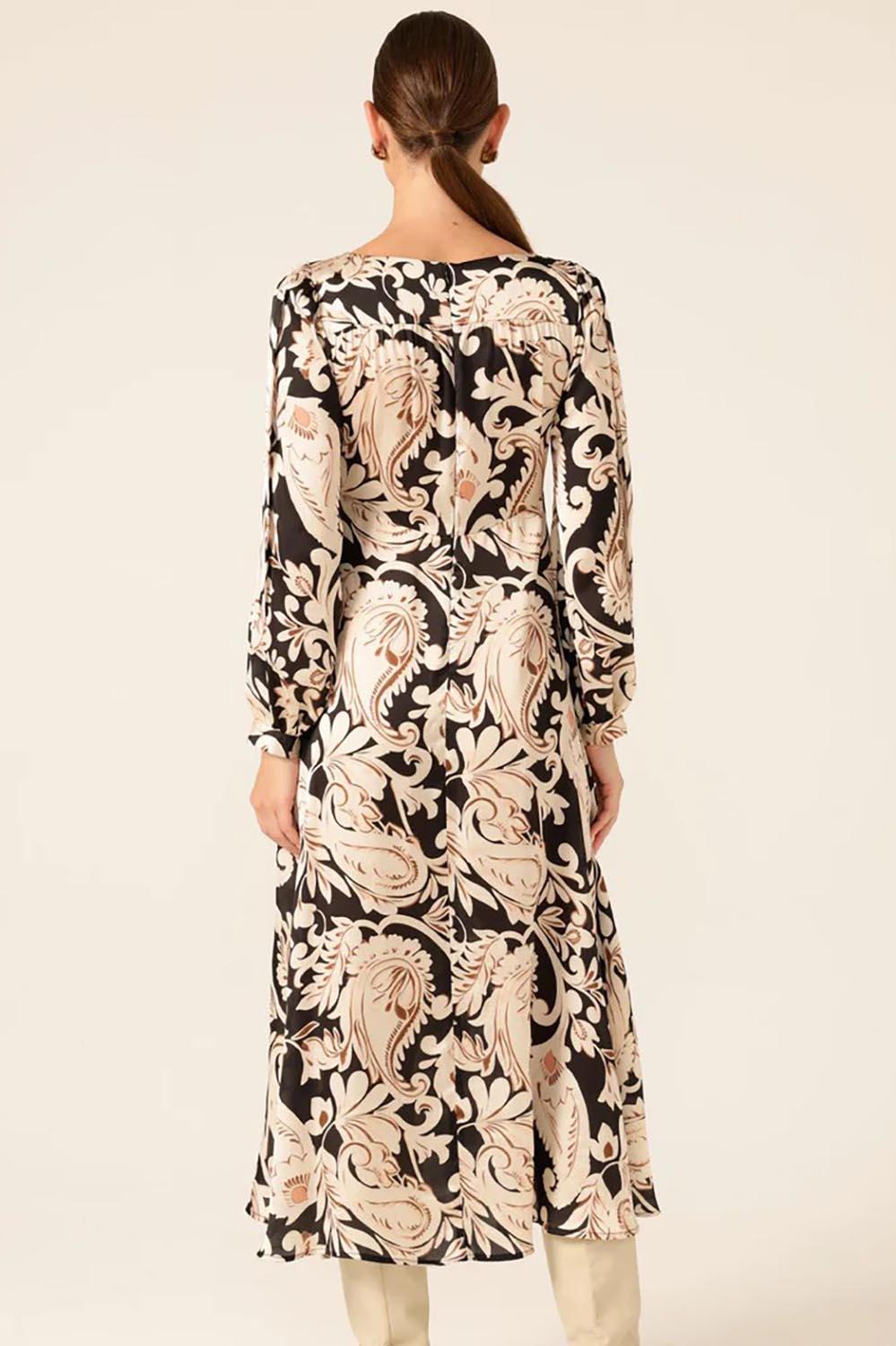 A model wearing the Charming Courtyard Dress in colour Blkcream, from the back