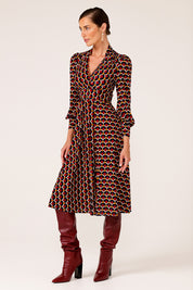 A model wearing the Auriga Dress in colour Ruby (Red), from the front, showing the whole outfit