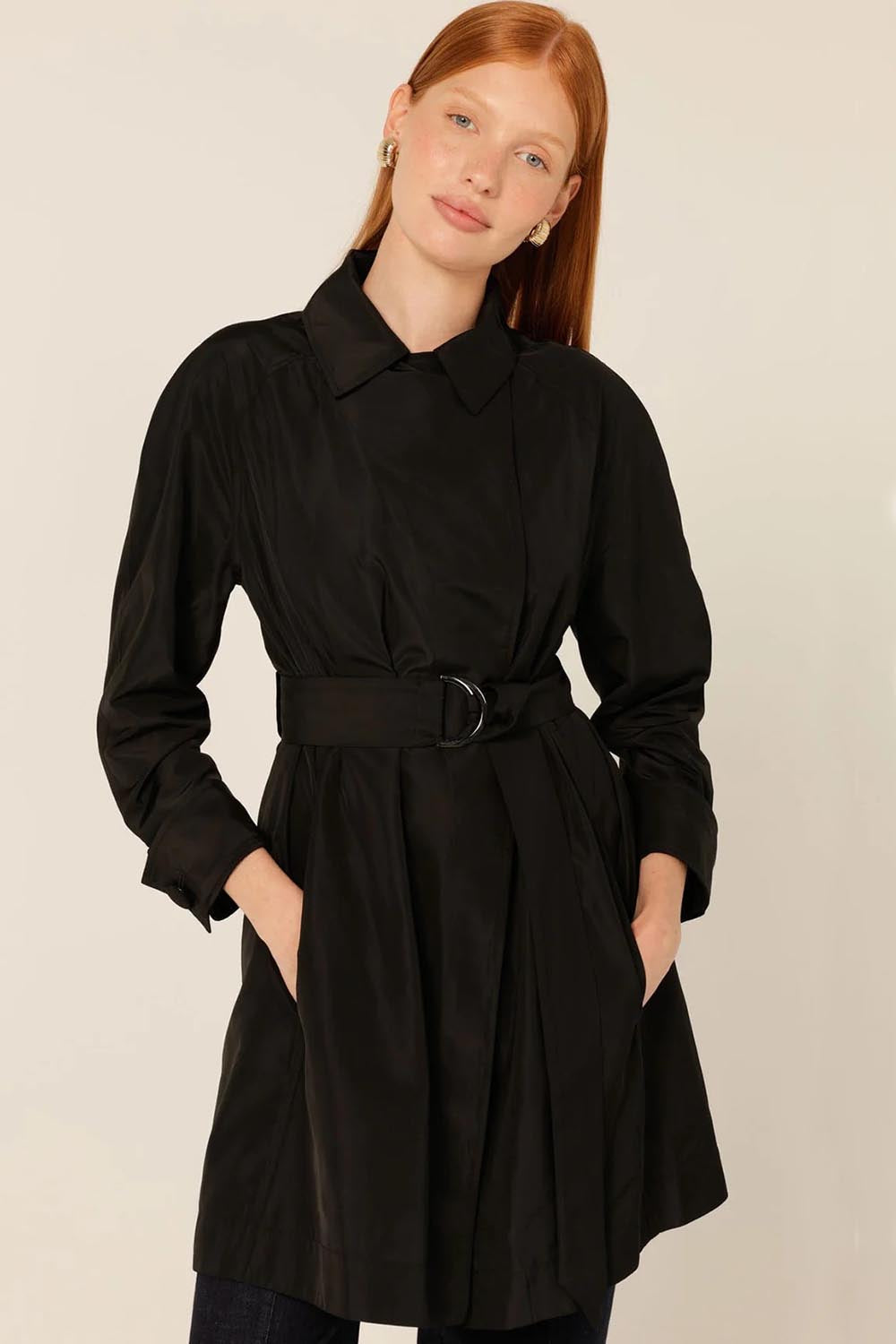 A model wearing the Noir Trench in colour Black (Black), from the front, cropped image