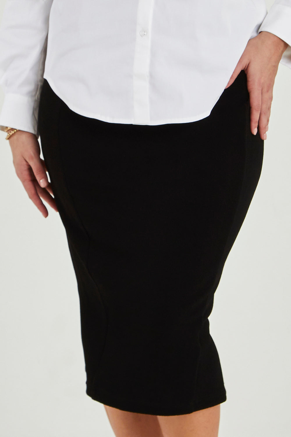 Model Maddy wearing size 16 of the Pencil Skirt in colour Black (Black), from the front, cropped image