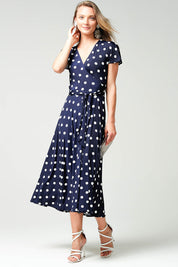 A model wearing the Reverse Wrap Midi Fluted Sleeve Dress in colour Polka (Blue), from the front, showing the whole outfit