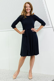 Model Katie wearing size 10 of the Reverse Wrap Full Skirt Dress in colour Navy (Blue), from the front, showing the whole outfit
