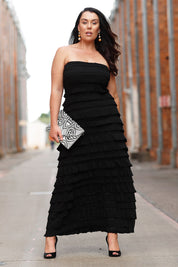 A model wearing the Maddison Maxi Ruffle Dress in colour Black (Black), from the front, showing the whole outfit