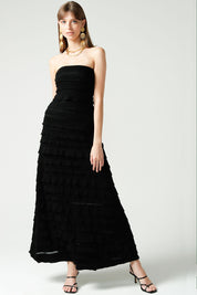 A model wearing the Maddison Maxi Ruffle Dress in colour Black (Black), from the front, showing the whole outfit