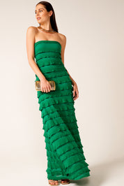 A model wearing the Maddison Maxi Ruffle Dress in colour Emerald (Green), from the front, showing the whole outfit