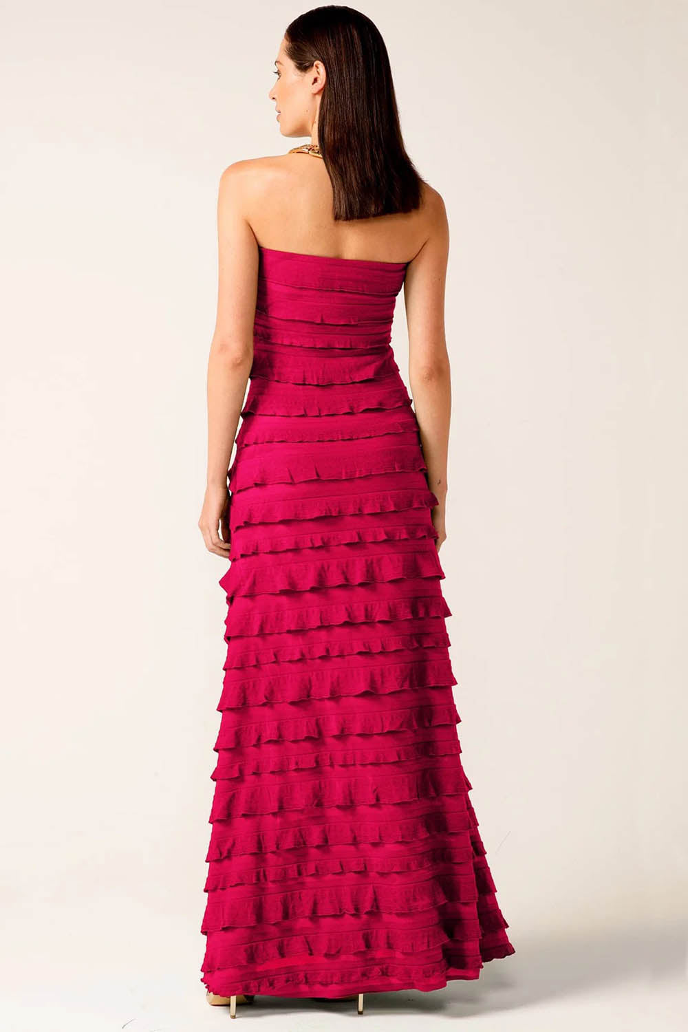 A model wearing the Maddison Maxi Ruffle Dress in colour Raspberry (Pink), from the back