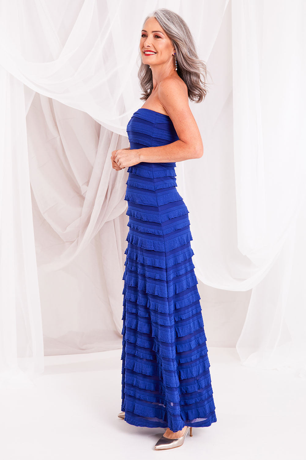 Model Luisa wearing size 10 of the Maddison Maxi Ruffle Dress in colour Sapphire (Blue), from the front, showing the whole outfit