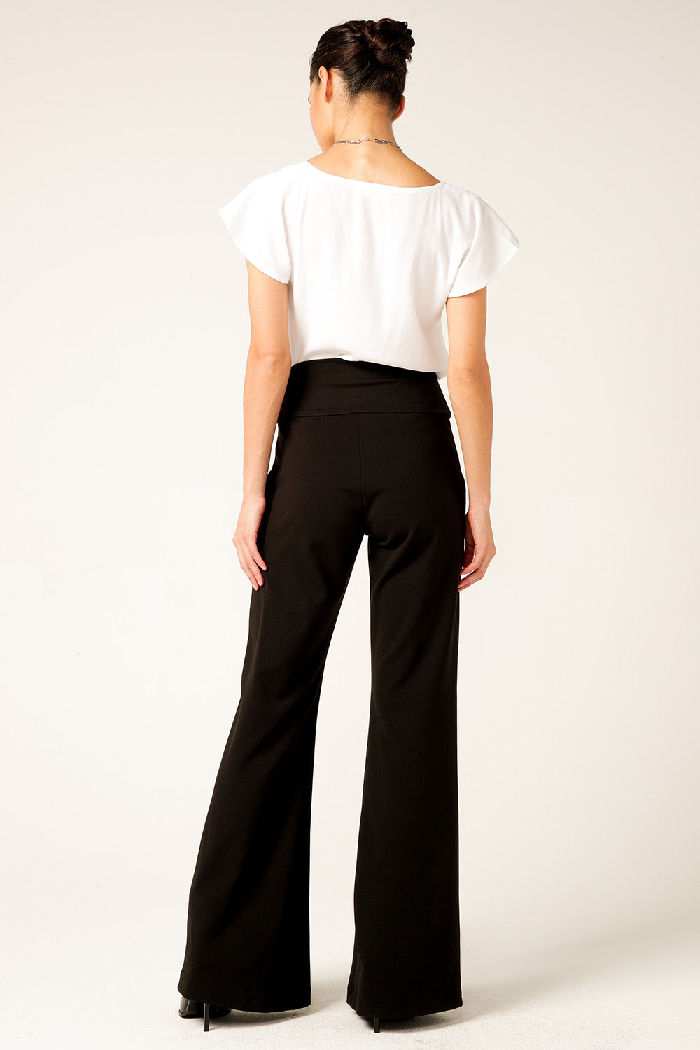 A model wearing the Classic Trouser in colour Black (Black), from the back