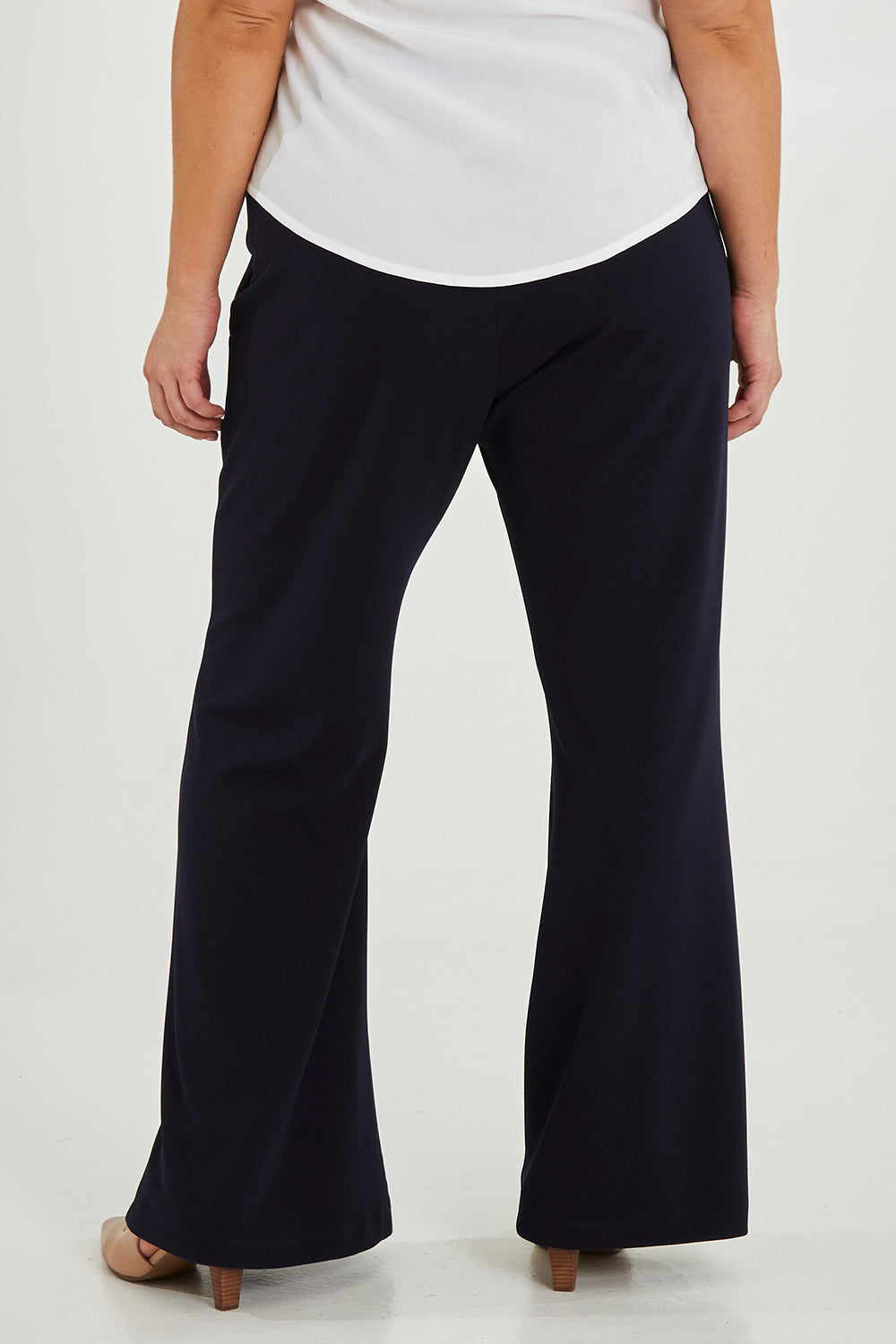 Model Maddy wearing size 16 of the Classic Trouser in colour Navy (Blue), from the back
