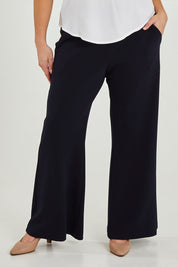 Model Maddy wearing size 16 of the Classic Trouser in colour Navy (Blue), from the front, cropped image