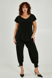 Model Maddy wearing size 16 of the Harem Pant in colour Black (Black), from the front, showing the whole outfit