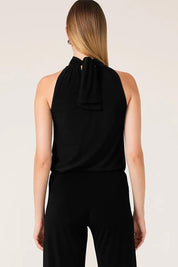 A model wearing the High Neck Tie Top in colour Black (Black), from the back