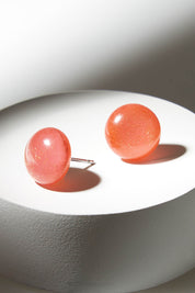 A model wearing size OneSize of the Medium Glass Stud Earrings in colour Coralgold, from the front, showing the whole outfit