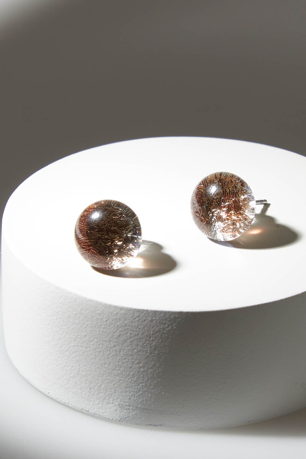 A model wearing size OneSize of the Small Glass Stud Earrings in colour Bronze (Metallics), from the front, showing the whole outfit