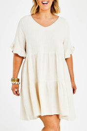 Model Jess wearing size 14 of the Gia Dress in colour Natural, from the front, cropped image