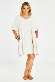 Model Jess wearing size 14 of the Gia Dress in colour Natural, from the front, showing the whole outfit
