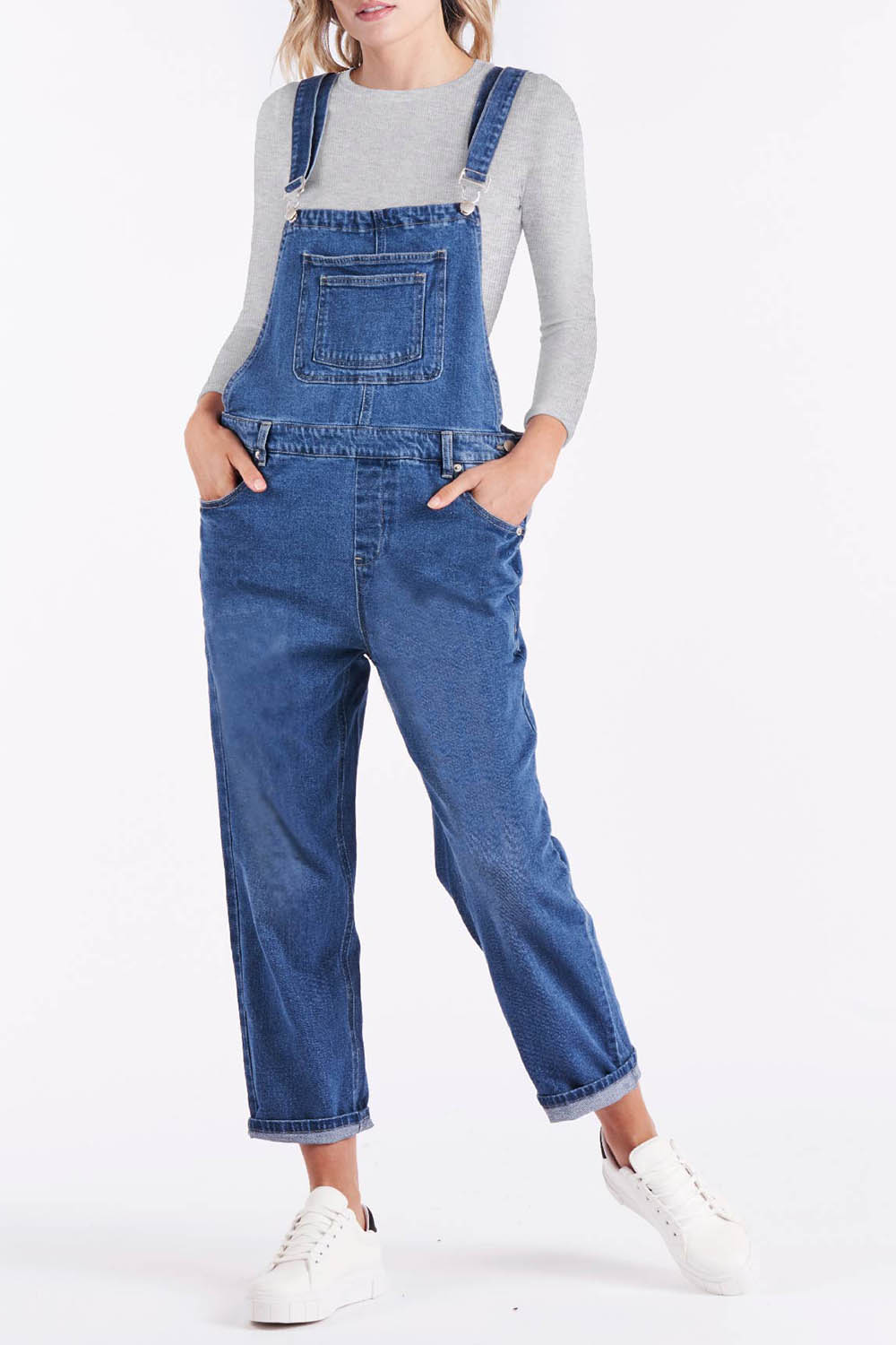 A model wearing the Simone Dungaree in colour Wornwash (Blue), from the front, cropped image