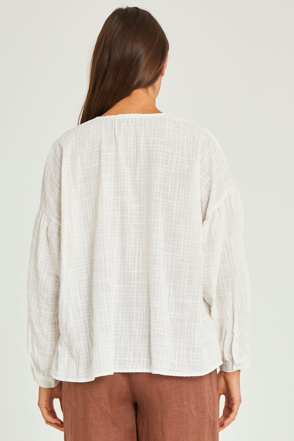 Model Elhana wearing size 10 of the Cerise Top in colour White (White), from the back