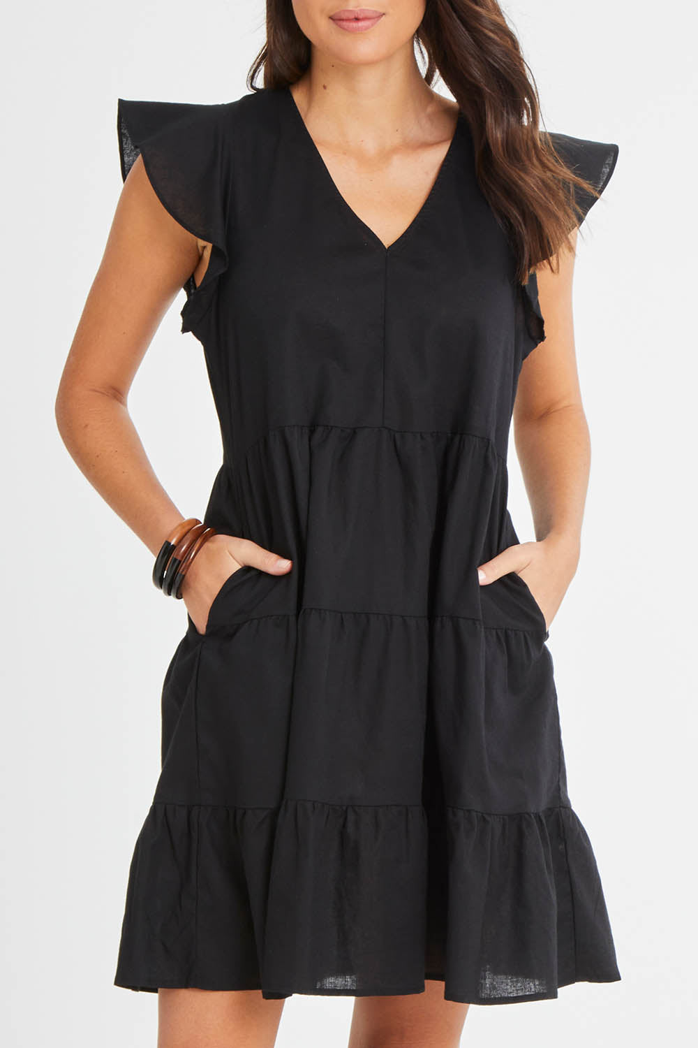 Model Madeline wearing size 10 of the Alina Tiered Linen Dress in colour Black (Black), from the front, cropped image