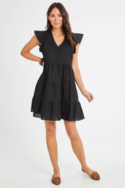 Model Madeline wearing the Alina Tiered Linen Dress in colour Black (Black), from the front, showing the whole outfit