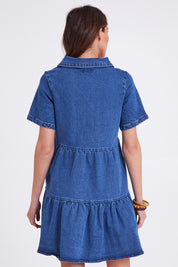 Model Madeline wearing size 10 of the Kellie Denim Dress in colour 80Wash (Blue), from the back
