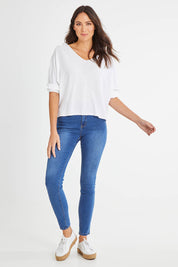 Model Madeline wearing size 10 of the Donna Knit Top in colour White (White), from the front, showing the whole outfit
