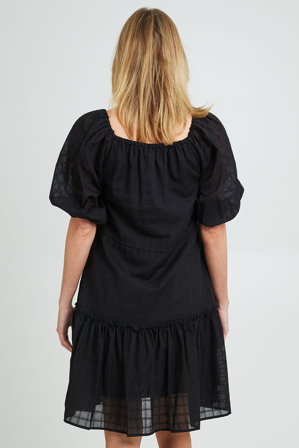 Model Grace wearing size 10 of the Ruby Tiered Midi Dress in colour Black (Black), from the back