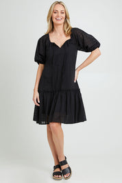 Model Grace wearing size 10 of the Ruby Tiered Midi Dress in colour Black (Black), from the front, showing the whole outfit