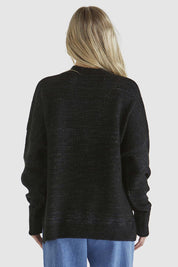 A model wearing the Kirsha Jumper in colour Black (Black), from the back