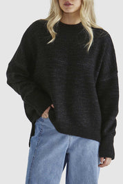 A model wearing the Kirsha Jumper in colour Black (Black), from the front, cropped image