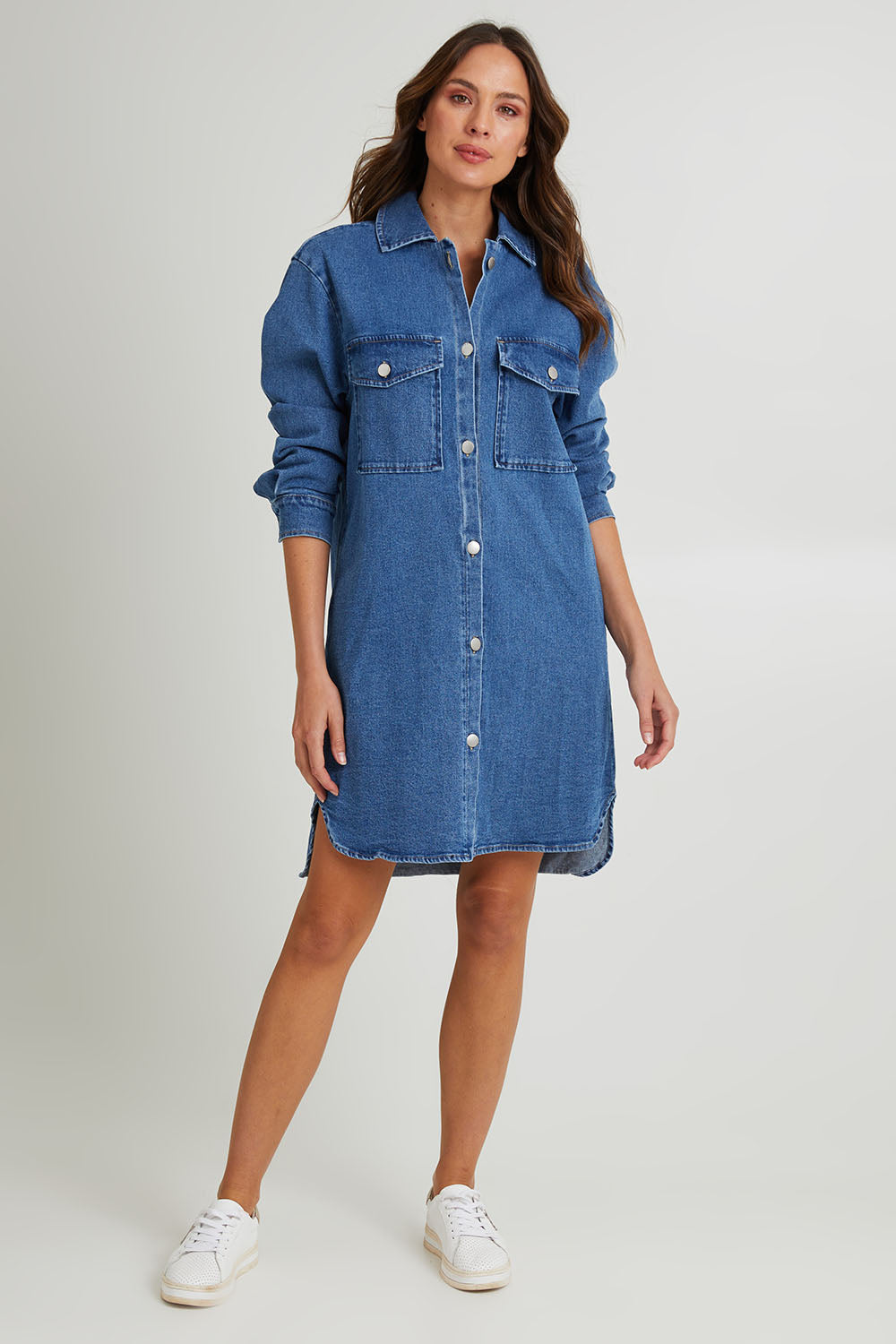 Model Madeline wearing size 10 of the Nya Long Denim Shacket Dress in colour 80Wash (Blue), from the front, showing the whole outfit