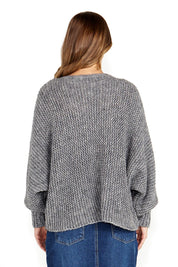 A model wearing the Belinda Chunky Cable Knit in colour Greymarle (Grey), from the back