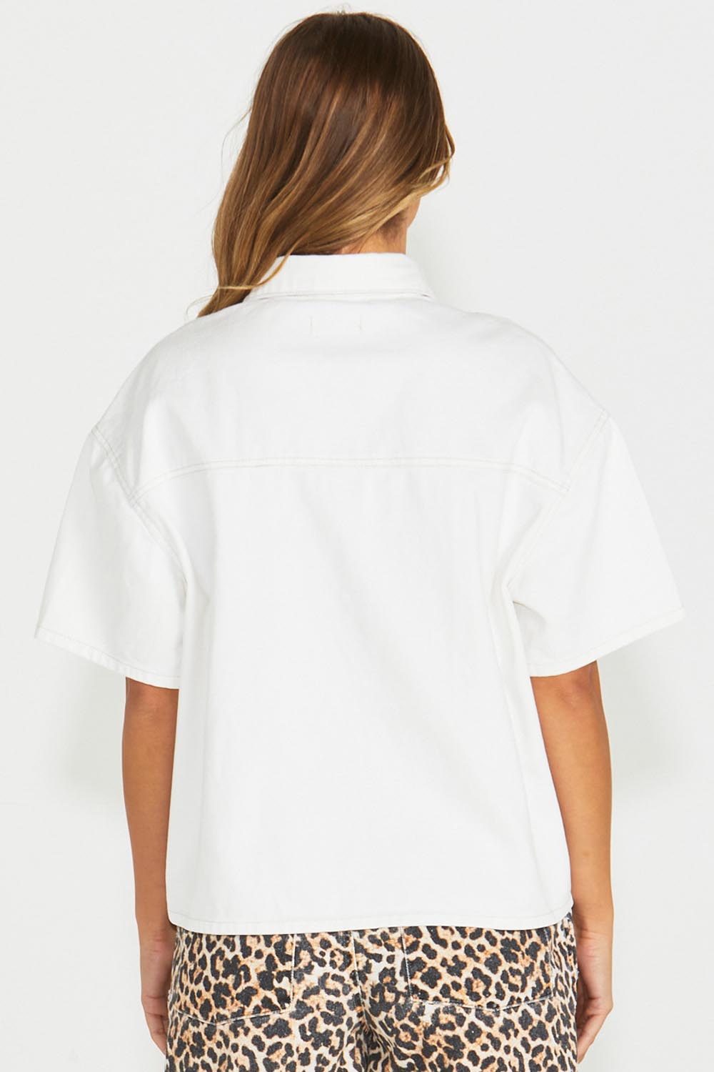 A model wearing the Wyatt Short Sleeve Denim Shirt in colour White (White), from the back