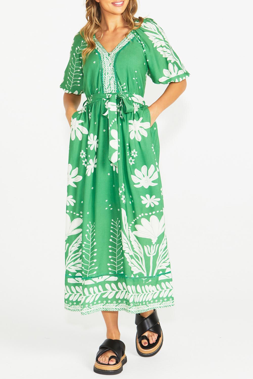 A model wearing the Lyndel Dress in colour Green (Green), from the front, cropped image